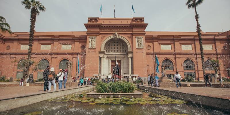 una fontana d'acqua e persone in piedi davanti al Museo Egizio
