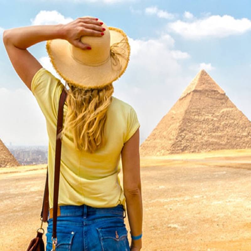 una donna in piedi davanti alle piramide durante tour egitto classico