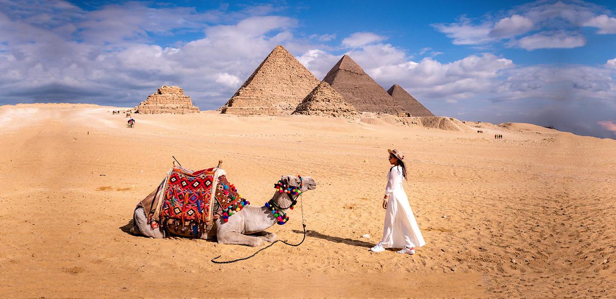 una donna davanti alle piramidi durante le vacanze in egitto in estate 2022