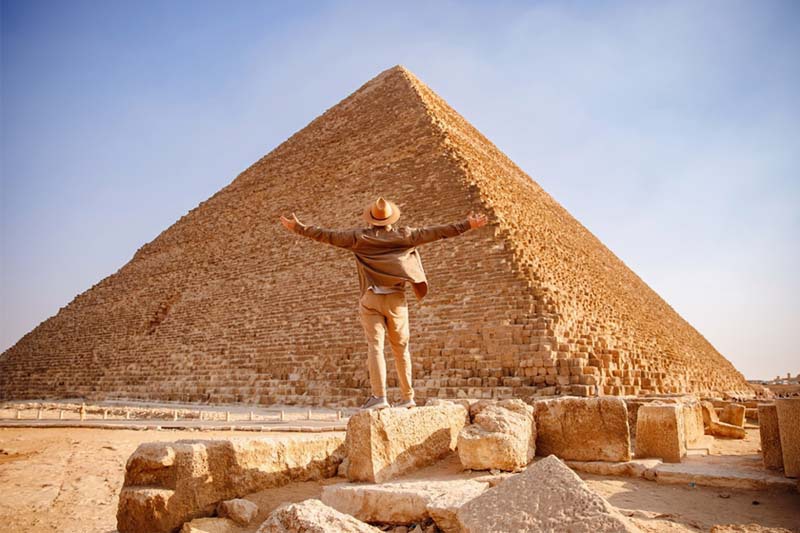 un uomo davanti la piramide di cheope