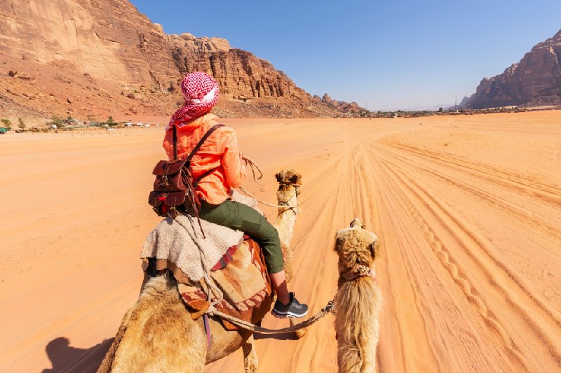 Deserto Wadi Rum, una donna a dorso sul cammello