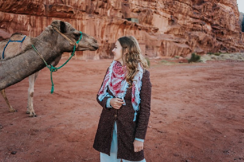 Deserto Wadi Rum, una donna accanto al cammello Deserto Wadi Rum, una donna accanto al cammello