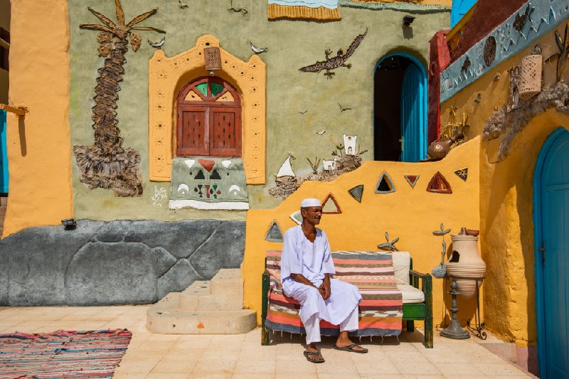 nubia egitto, un uomo che siede dentro l'entrata della casa nubiana nubia egitto, un uomo che siede dentro l'entrata della casa nubiana